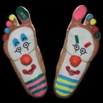 Funny feet painted with clown makeup.