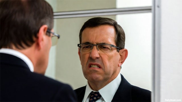Angry white male lawyer staring at his self in the mirror.