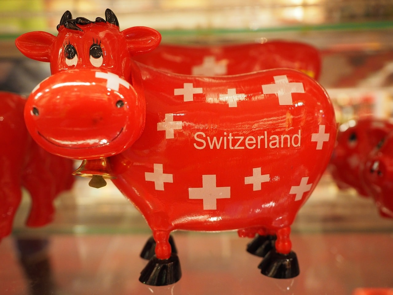 Toy red cow smiling with the word Switzerland on its belly.