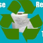 Toilet paper behind green recycle logo.