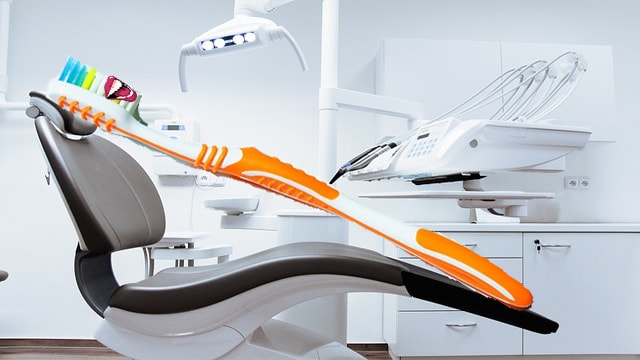 Funny photo of toothbrush with teeth sitting in dental chair.