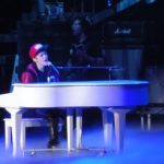 Pop musician Justin Beiber playing a piano in concert.