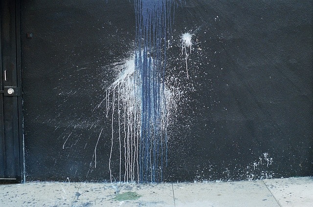 A black wall with splattered paint running down the side.
