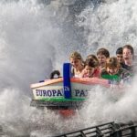 Children riding in an Europa Park amusement water ride with water splashing everywhere.