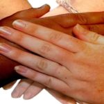 A white woman and black woman Azealia Banks' hands joining together to show unity.