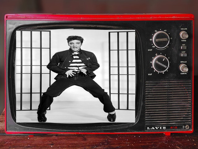 Black and white Elvis Presley dancing on red vintage TV in Tennessee apartment.