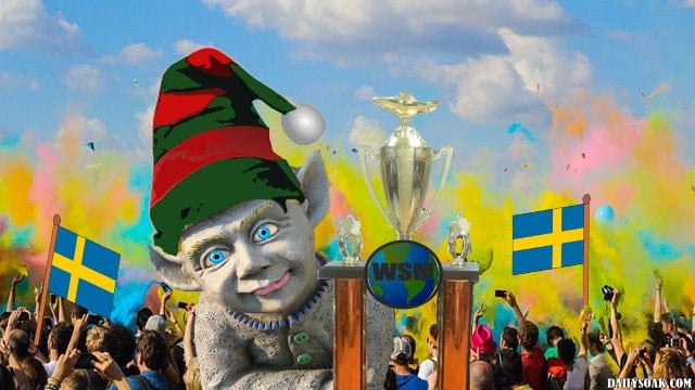 Little person holding a trophy in front of a large crowd.