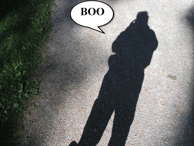 A large shadow of a man on a concrete sidewalk.