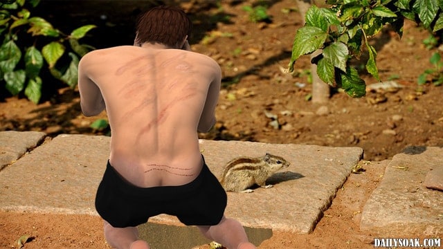 Shirtless man bending over to talk to a chipmunk in forest.