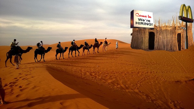Satire of ISIS members standing in line for work at McDonald's hut in desert.