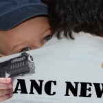 Funny photo of a baby with a gun robbing an adult man.
