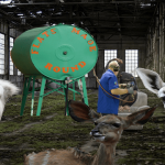 Numerous animals inside a manufacturing plant chewing food.