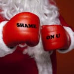 Santa Claus wearing red boxing gloves.