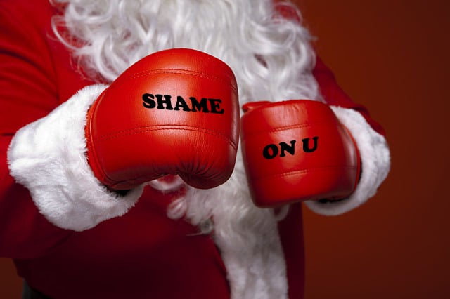 Santa Claus wearing red boxing gloves.