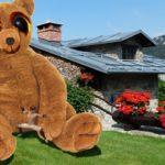 Funny photo showing 25 tall teddy bear outside a house.