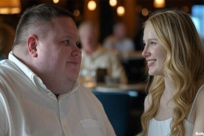 Big guy standing next to a skinny woman inside of a restaurant.