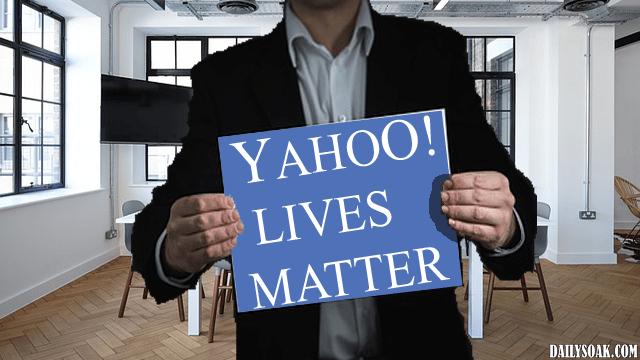Man wearing black suit holding up sign that reads Yahoo Lives Matter.