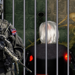 Armed guard wearing black guarding old man in wheelchair behind bars.