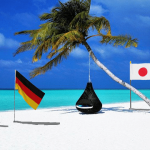 Sunny Maldives beach with many countries flags on poles.