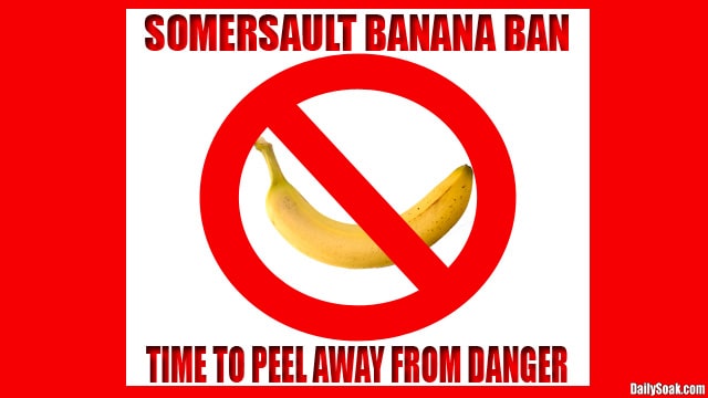 Red banned sign over banana against red and white background.