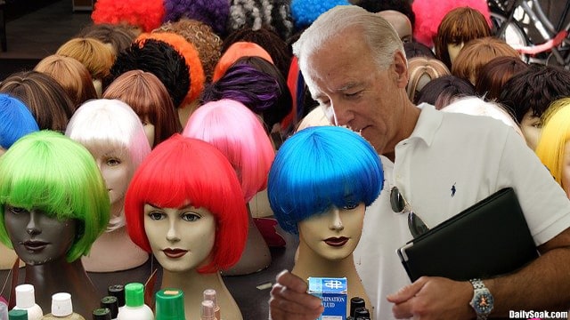 Joe Biden wearing white shirt in front of mannequin heads.