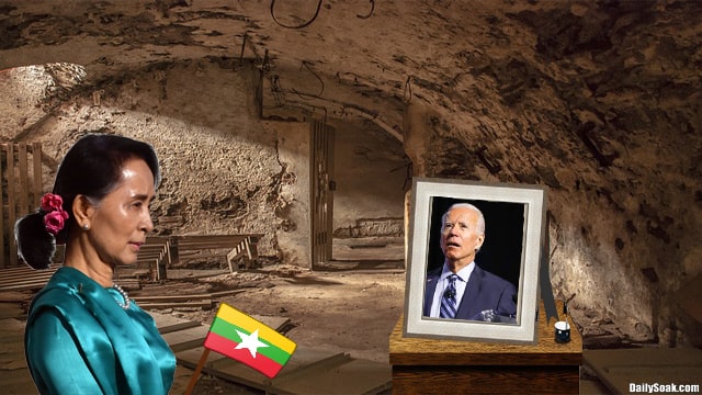Aung San Suu Kyi in blue dress in basement looking at photo of Joe Biden.
