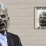 Zombie wearing gray suit standing against white brick wall.