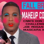 News host Don Lemon wearing gray suit and makeup against pink background.