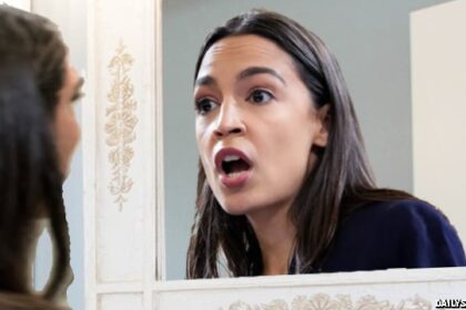 AOC wearing white suit staring into her reflection inside restroom mirror.