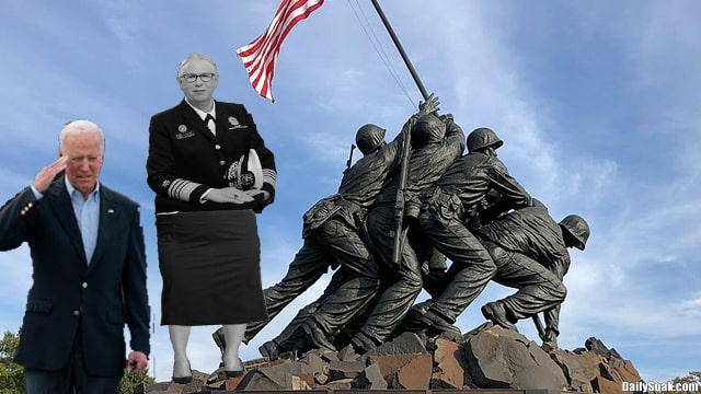 Joe Biden wearing blue suit saluting statue of Marine Corps War Memorial.
