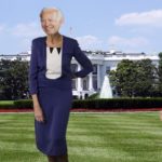 Joe Biden wearing a blue dress while standing on the White House lawn grass.