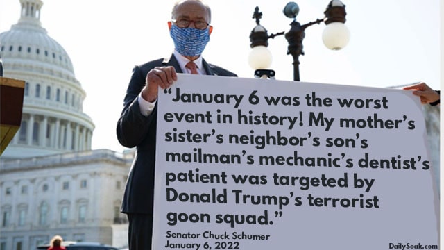 Chuck Schumer holding a white sign in front of Capitol Hill.