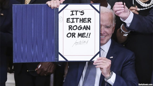 Joe Biden holding up an executive order paper sign.