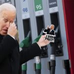 Joe Biden holding 'I Did That' sticker at gas station.