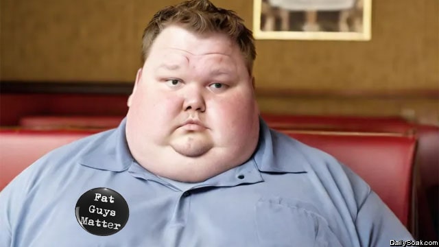 Fat obese man in gray shirt standing in front of buffet table.