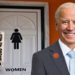 Joe Biden standing near a women's bathroom painted orange for Halloween.