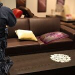 Police officer at scene of pillow fight inside living room.