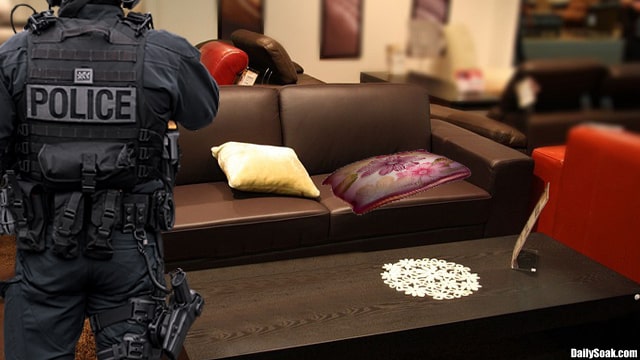 Police officer at scene of pillow fight inside living room.