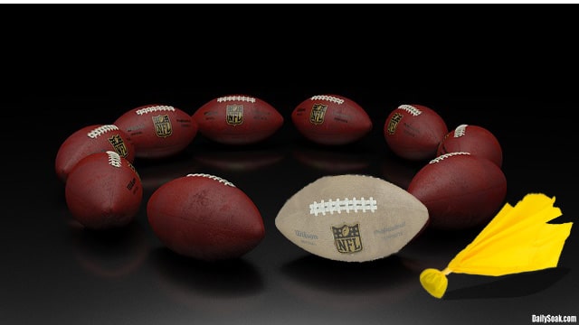 NFL footballs lined up in a circle on ground.