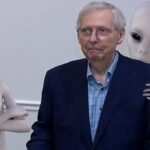 Mitch McConnell freezing during a speech while surrounded by gray aliens.