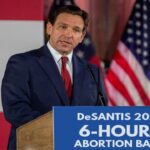 Ron DeSantis giving speech at podium on abortion ban.