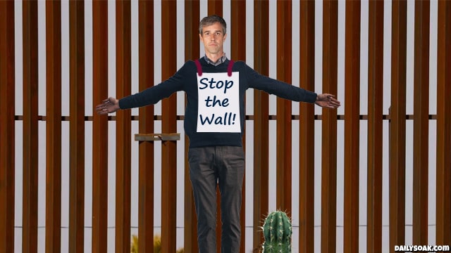 Beto O'Rourke hanging from the Texas border wall.