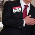 Man in suit inside doctor's office having a heart attack.
