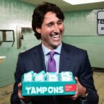 Justin Trudeau holding a box of tampons inside men's bathroom.