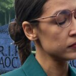 AOC crying inside of a graveyard.