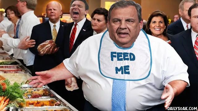 Chris Christie standing in front of a buffet line wearing a baby's bib.
