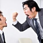 Japanese boss in business suit yelling at his Japanese male employee.