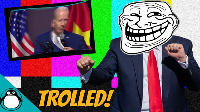 Donald Trump wearing a white troll face mask in front of Joe Biden,
