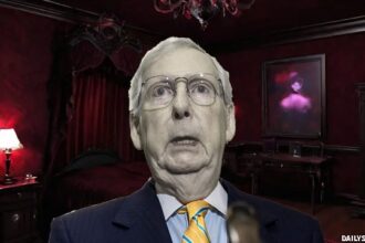 Mitch McConnell standing inside of a dark, red vampire's room.