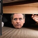 California Governor Gavin Newsom hiding under his bed in fear of guns.